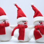 Three snowmen in red hats and scarves