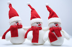 Three snowmen in red hats and scarves